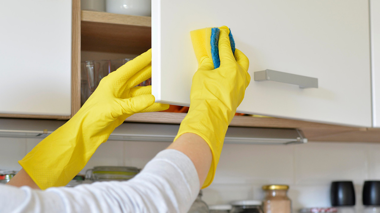 wiping kitchen cupboard